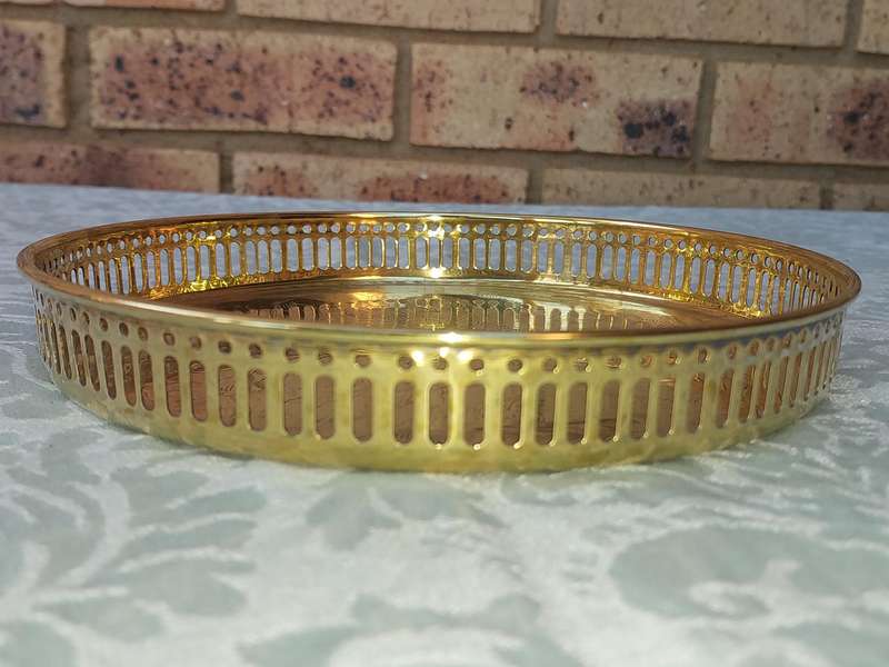 A BRASS SERVING TRAY MADE IN INFIA SOLD AS IS