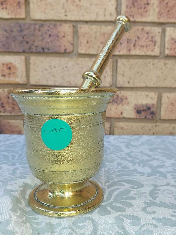 A HEAVY DUTY BRASS PASTEL AND MORTER SOLD AS IS
