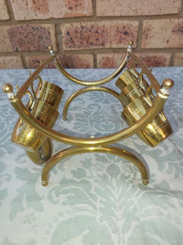 A VINTAGE HEBREW WINE DECANTER AND SIX CUPS BRASS ON A STAND ONE CUP NEED THE HANDLE TO BE ATTACHED