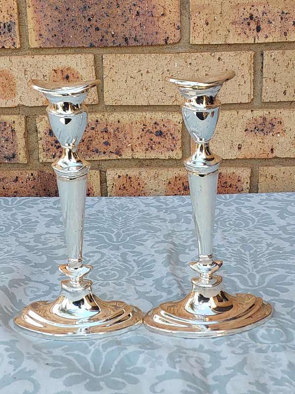 A PAIR OF ORNATE ART DECOR SILVER PLATED CANDLE HOLDERS SOLD AS IS