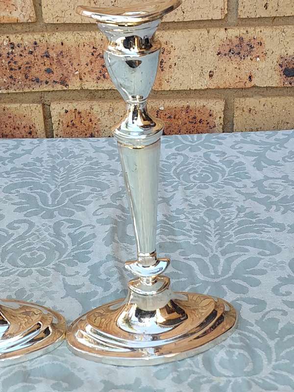 A PAIR OF ORNATE ART DECOR SILVER PLATED CANDLE HOLDERS SOLD AS IS
