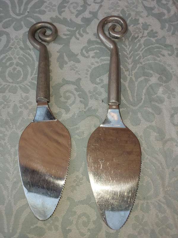 A PAIR OF PEWTEL CARROL BOYES STYLE CAKE CUTTERS SOLD AS IS