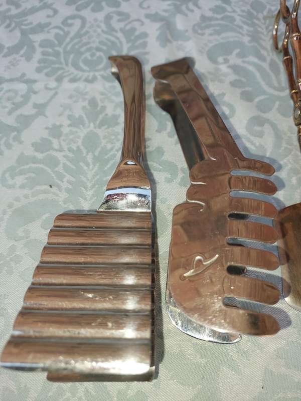 A COLLECTION OF CUTLERY TONGS SOLD AS IS
