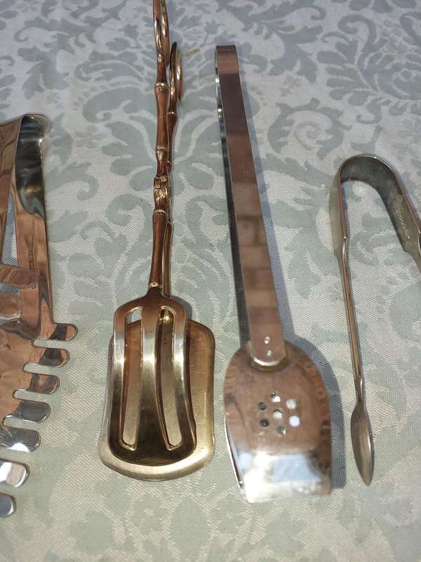 A COLLECTION OF CUTLERY TONGS SOLD AS IS