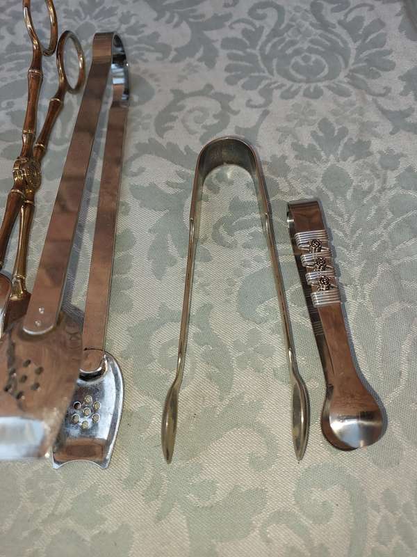 A COLLECTION OF CUTLERY TONGS SOLD AS IS