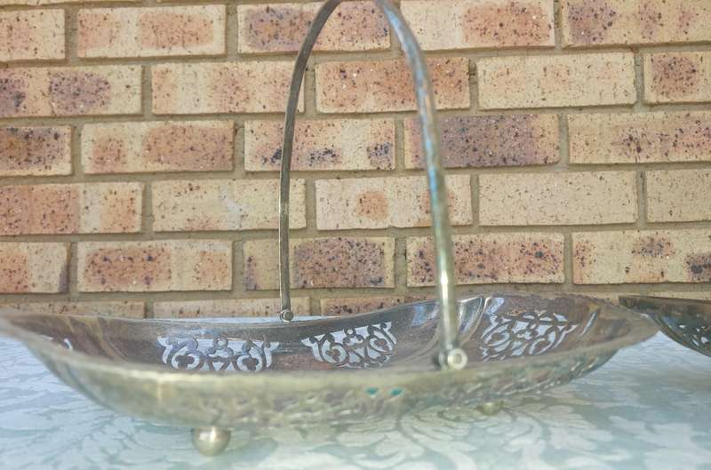 A PAIR OF SILVERPLATED TEMPLE DECOR HANDLED SERVING BASKETS SOLD AS IS