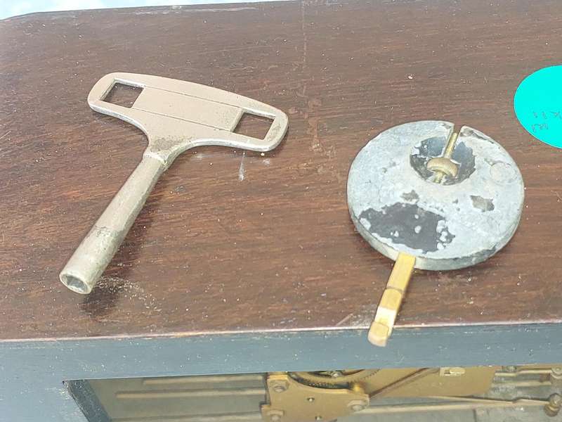 AN ANTIQUE PADESTAL CLOCK WITH THE WINDING KEYS MADE IN ENGLAND AND CHIMES SOLD AS IS