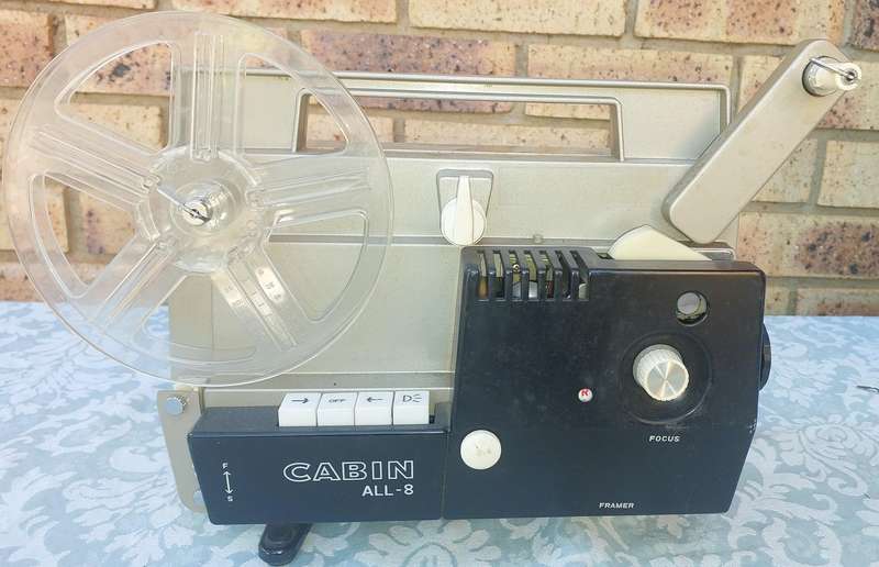 AN ANTIQUE MOVIE PROJECTOR WIYHOUT THE POWER CABLE SOLD AS IS NOT TESTED