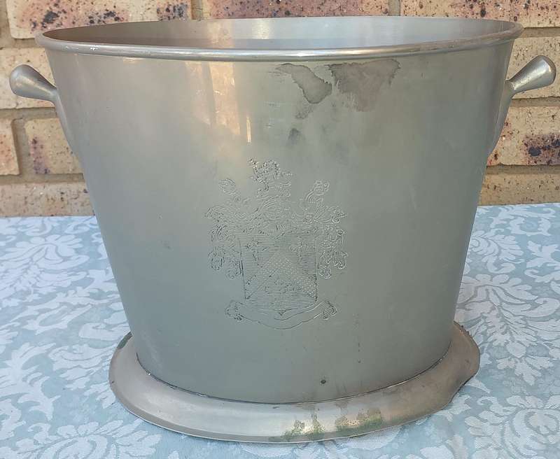 AN EXCLUSIVE CHAMPAIGNE ICE BUCKET WITH A COAT OF ARMS ENGRAVED SOLD AS IS