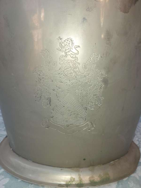 AN EXCLUSIVE CHAMPAIGNE ICE BUCKET WITH A COAT OF ARMS ENGRAVED SOLD AS IS
