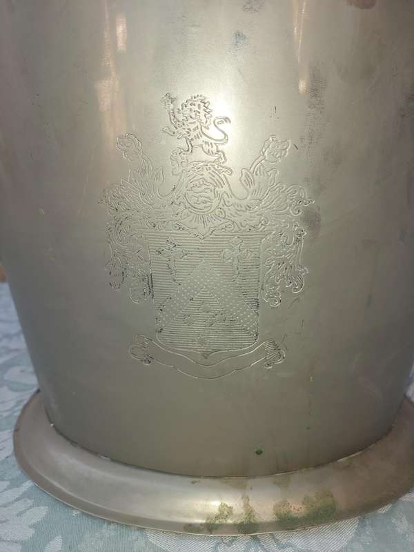 AN EXCLUSIVE CHAMPAIGNE ICE BUCKET WITH A COAT OF ARMS ENGRAVED SOLD AS IS