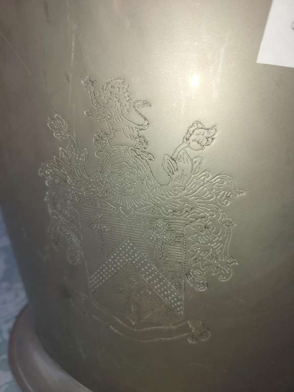 AN EXCLUSIVE CHAMPAIGNE ICE BUCKET WITH A COAT OF ARMS ENGRAVED SOLD AS IS