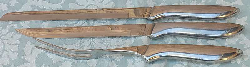 A VINTAGE STAINLESS STEEL CARVING SET SOLD AS IS