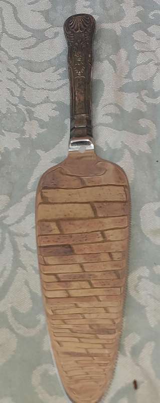 A VINTAGE CAKE CUTTER WITH SILVER HANDLE SOLD AS IS