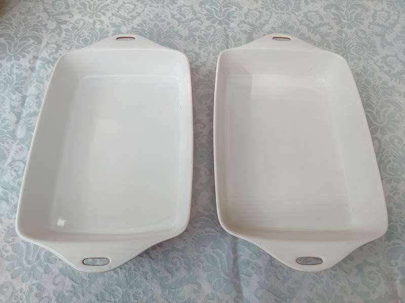 A PAIR OF RED AND WHITE CASSEROLE DISHES IN GOOD CONDITION SOLD AS IS