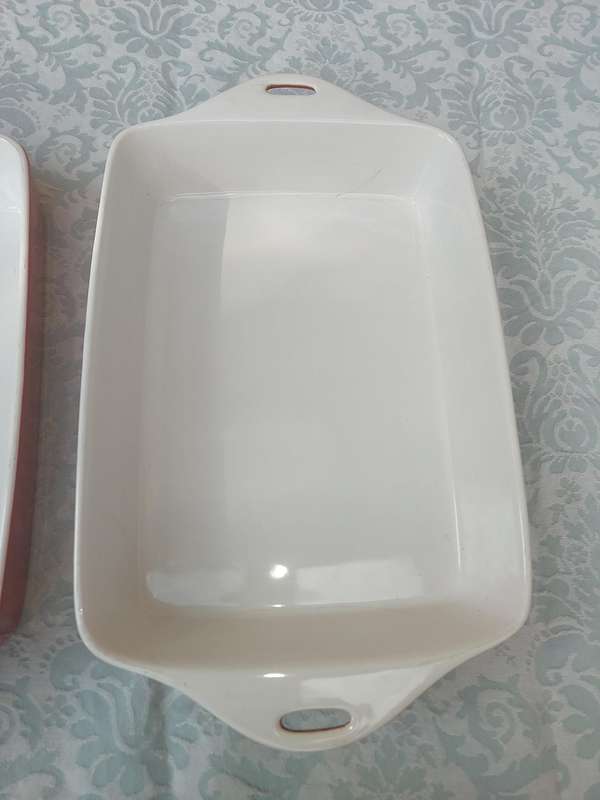 A PAIR OF RED AND WHITE CASSEROLE DISHES IN GOOD CONDITION SOLD AS IS