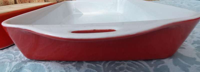 A PAIR OF RED AND WHITE CASSEROLE DISHES IN GOOD CONDITION SOLD AS IS