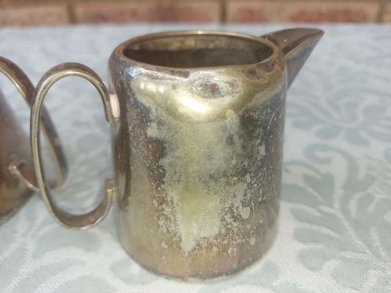 A VINTAGE SET OF SILVER PLATED MILK JUG AND SUGAR BOWL SOLD AS IS