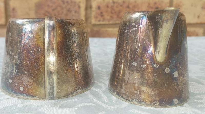 A VINTAGE SET OF SILVER PLATED MILK JUG AND SUGAR BOWL SOLD AS IS