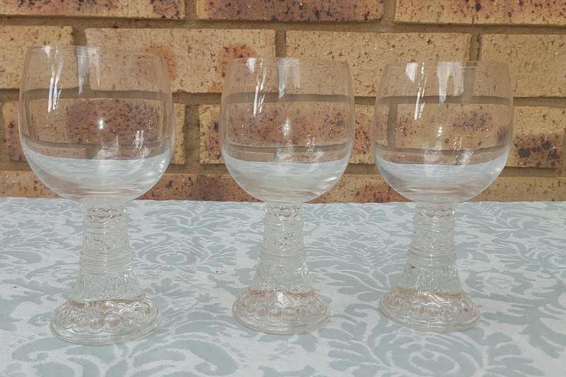 A SET OF SIX GLASS WINE GLASSES SOLD AS IS