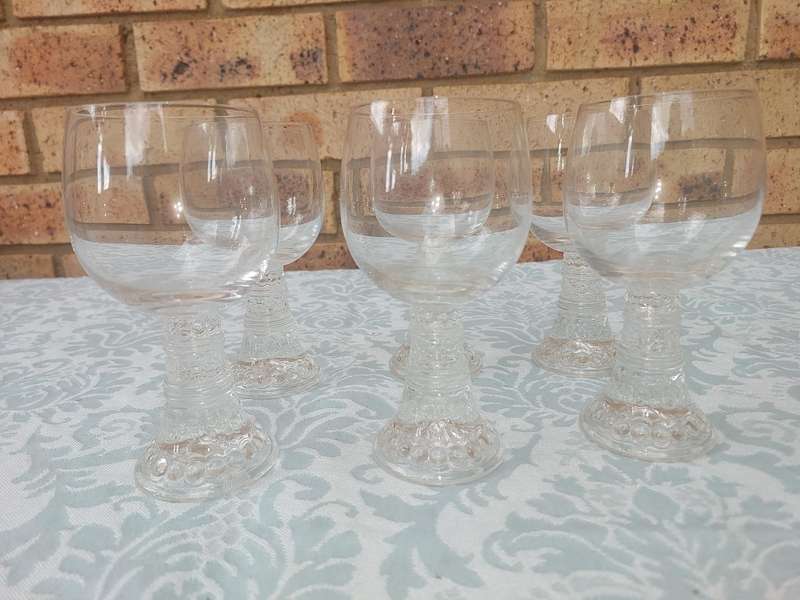 A SET OF SIX GLASS WINE GLASSES SOLD AS IS