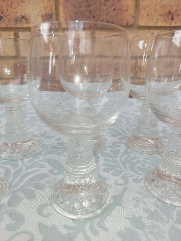 A SET OF SIX GLASS WINE GLASSES SOLD AS IS