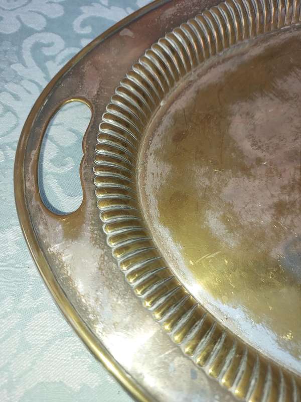 AN OVAL VICTORIAN SILVERPLATED ON BRASS TRAY SOLD AS IS