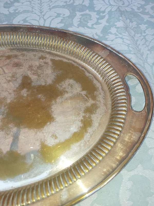 AN OVAL VICTORIAN SILVERPLATED ON BRASS TRAY SOLD AS IS
