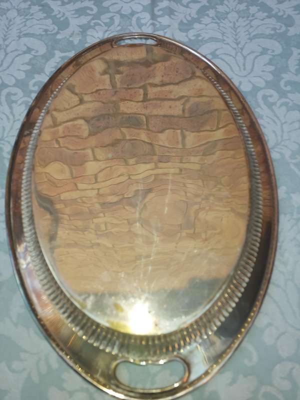 AN OVAL VICTORIAN SILVERPLATED ON BRASS TRAY SOLD AS IS