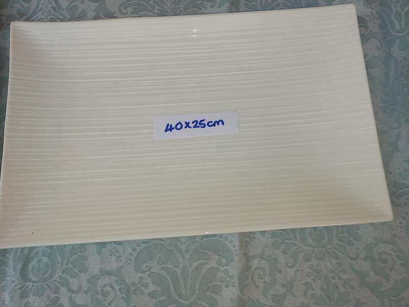 A COLLECTION OF WHITE PORCELAIN PLATTERS SOLD AS IS