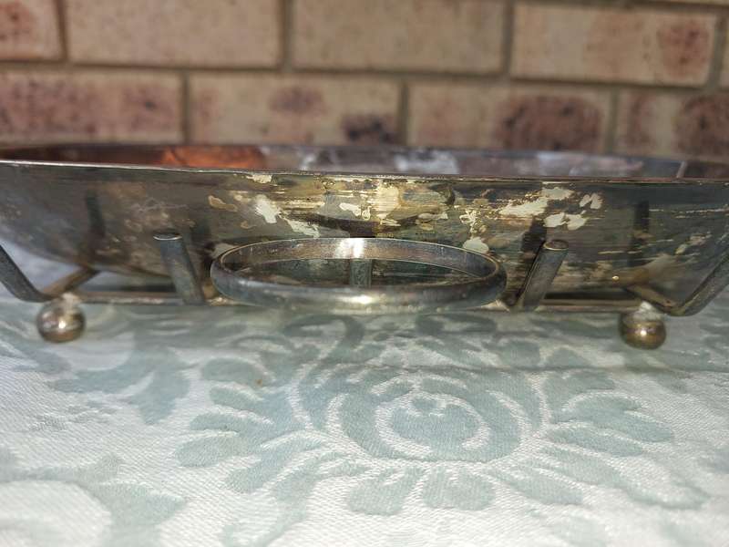 A VINTAGE SILVER PLATED SERVING PLATTER ON A SERVING STAND SOLD AS IS