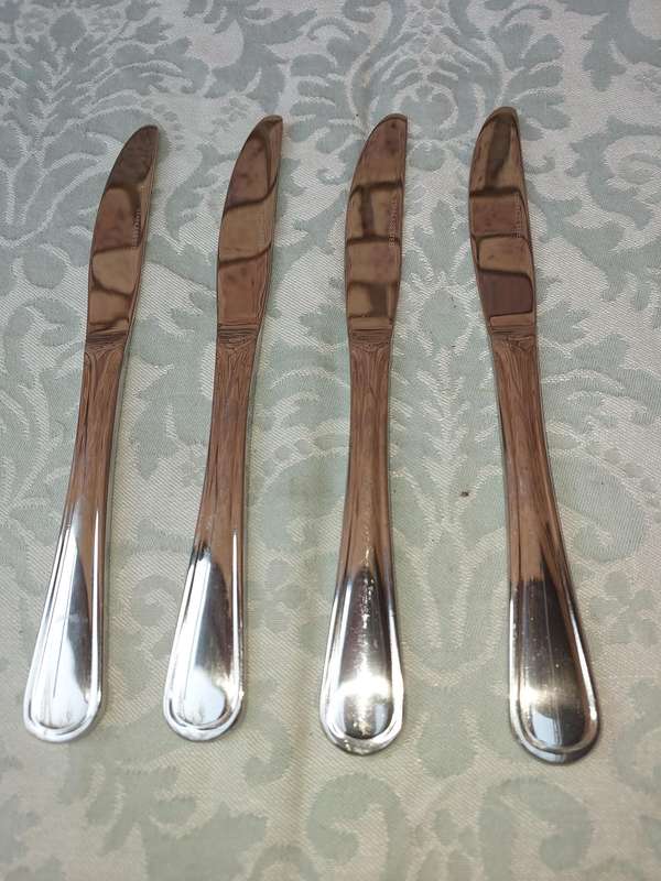 A SET OF 4 STAINLESS STEEL KNIVES SOLD AS IS