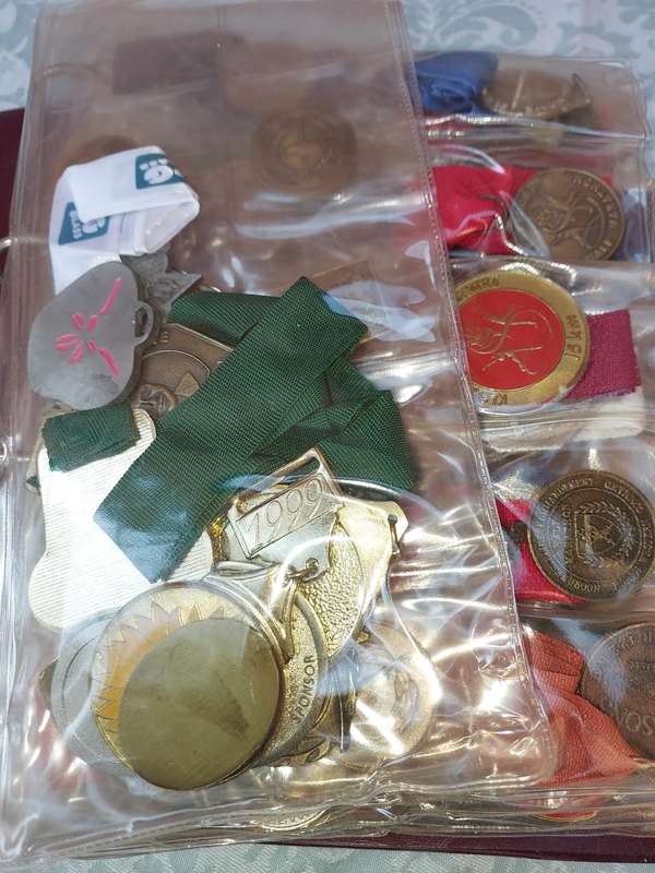 AN ENTIRE ATHLETES ALBUM WITH ALL THE MEDALS SOLD AS IS