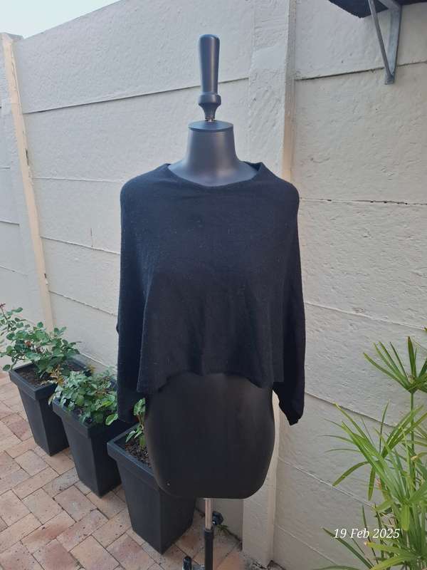 Black knit asymmetrical hemline knit poncho by Divided H&M. One size
