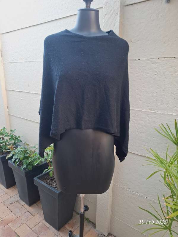 Black knit asymmetrical hemline knit poncho by Divided H&M. One size