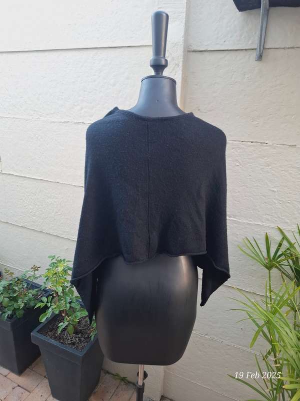 Black knit asymmetrical hemline knit poncho by Divided H&M. One size