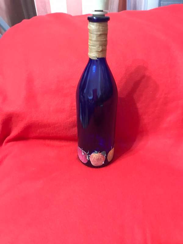 Cobalt bottle with printed apples and has a top