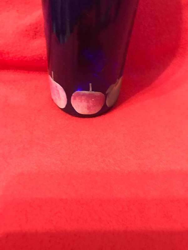 Cobalt bottle with printed apples and has a top