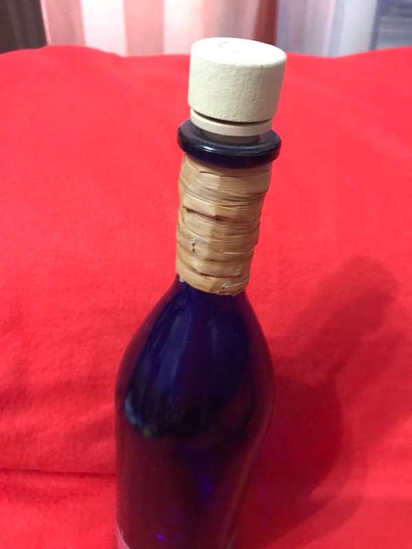 Cobalt bottle with printed apples and has a top