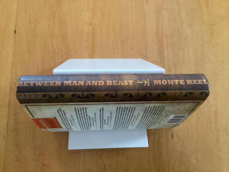 BETWEEN MAN and BEAST. True Story, by Monte Reel. Hardcover in a VG+ condition.