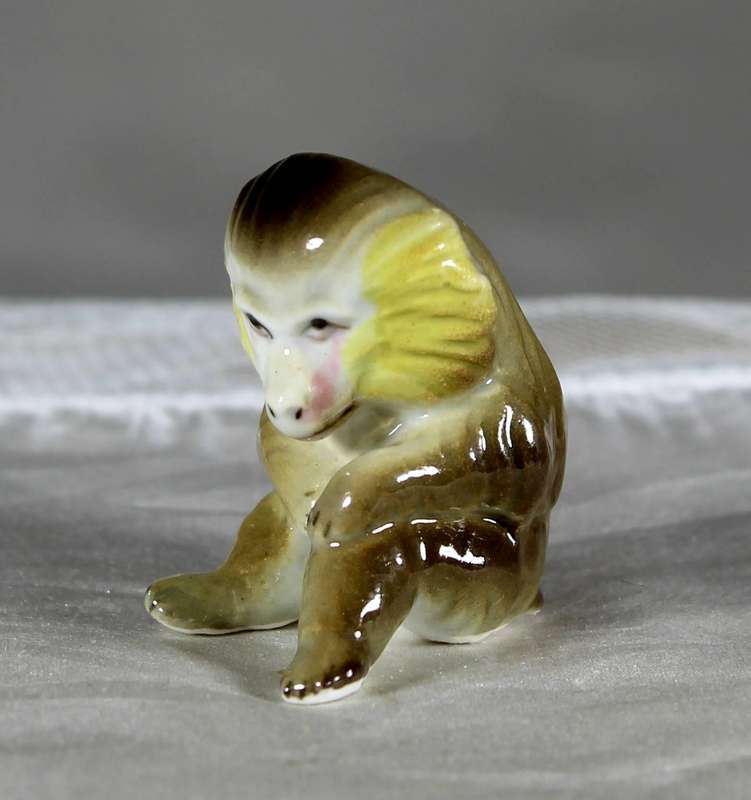 Miniature porcelain seated baboon