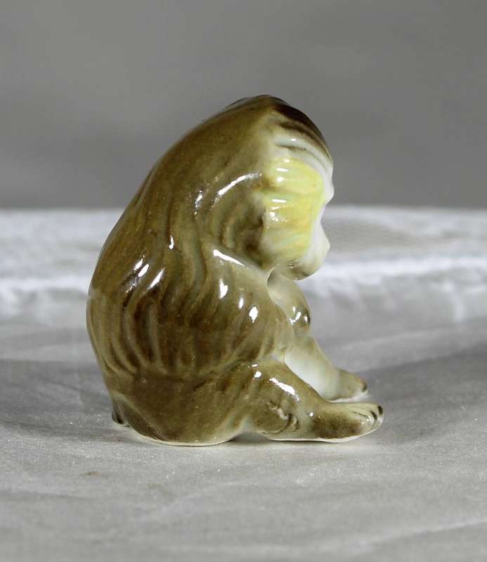 Miniature porcelain seated baboon