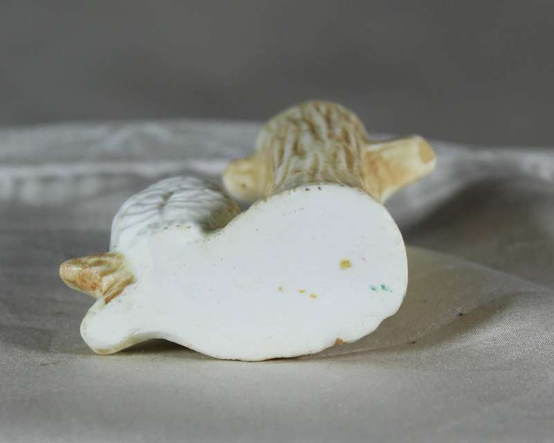 Miniature porcelain owl on a tree trunk