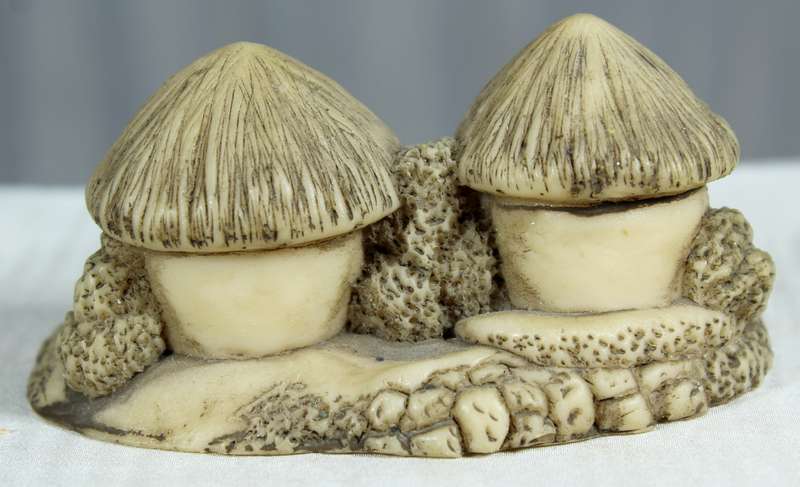 Miniature African huts with people sitting in front