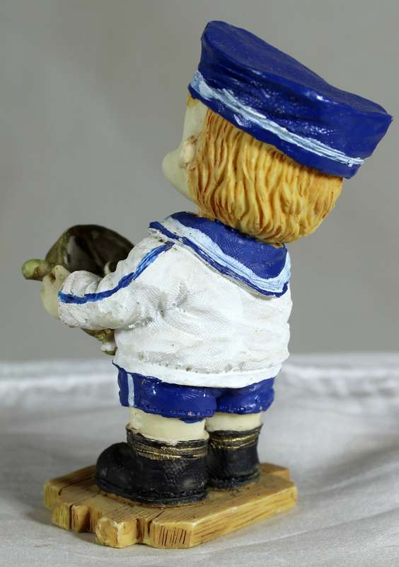 Boy sailor figure holding a ships wheel
