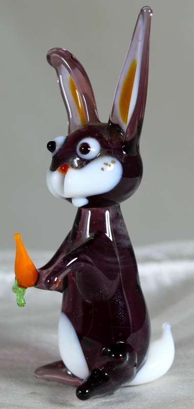 Glass rabbit seated with carrot