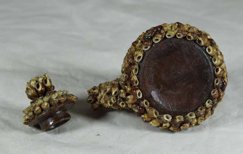 Small ceramic tea pot covered with shells
