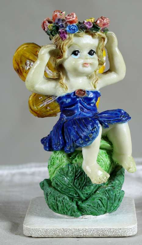 Seated fairy holding a flower crown