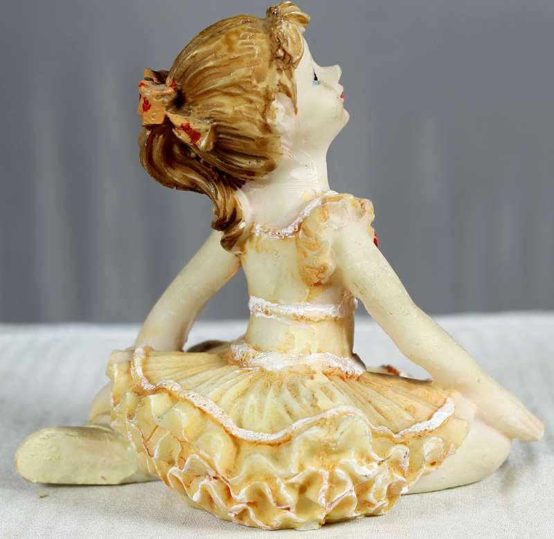 Little ballerina figurine sitting on floor