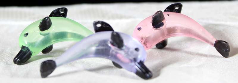 Miniature hardened plastic dolphin trio
